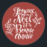 Red Joyeux Noël and Bonne Année Christmas Classic Round Sticker<br><div class="desc">Add a festive French touch to your holiday gifts and cards with this sticker featuring “Joyeux Noël et Bonne Année” in modern calligraphy accented by holly illustrations. Perfect for decorating presents,  planners,  and holiday crafts,  this sticker brings elegance and seasonal cheer to any project.</div>