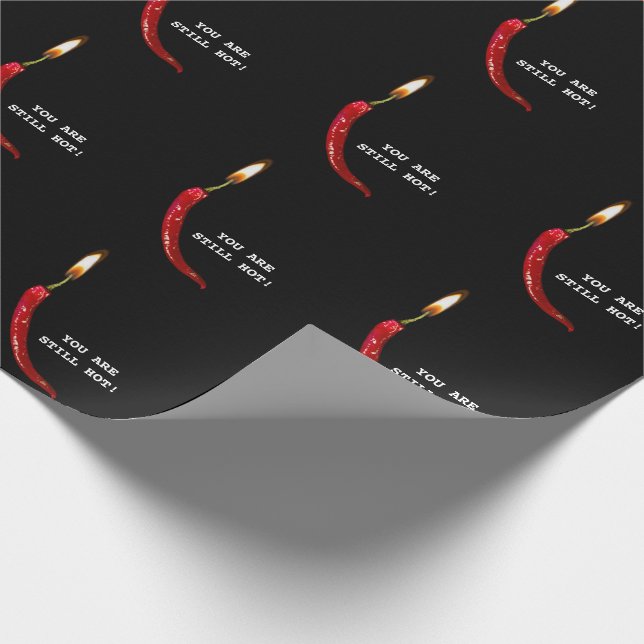 Red pepper with candle flame on black wrapping paper (Corner)