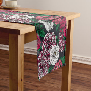 Red, white and bi-color roses with green leaves on short table runner