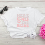 Retro Here Comes The Bride Bachelorette Party T-Shirt<br><div class="desc">Cute bride's bachelorette party t-shirt featuring "Here Comes The Bride" in a large pink and taupe retro 70's style font and an illustration of a daisy. A coordinating "Here Comes The Party" t-shirt is available for the bachelorette squad.</div>