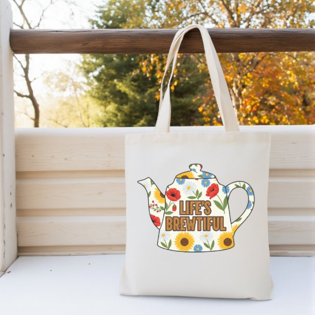 Retro teapot life's brewtiful design tote bag (A flowered cream teapot with teabag coloured words that spell 'Life's Brewtiful'.  )