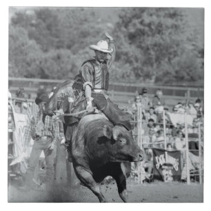 Rider hanging on to bucking bull 2 tile