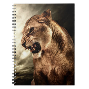 Roaring lioness against stormy sky notebook