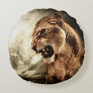 Roaring lioness against stormy sky round cushion