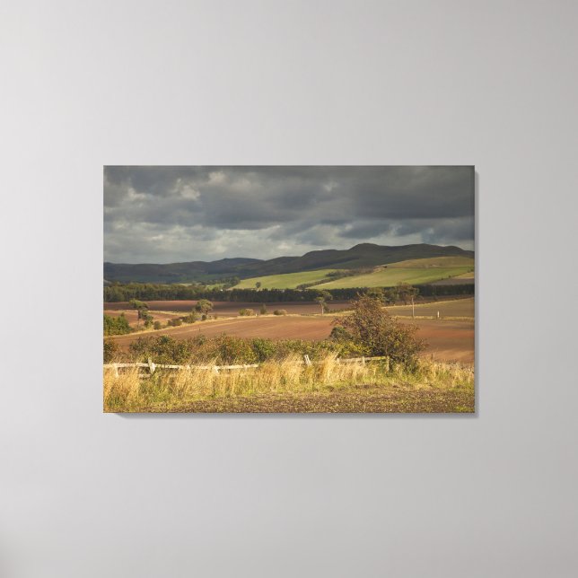 Rolling Hills And Mountains Under A Cloudy Sky Canvas Print (Front)