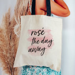 Rosé the Day Away Tote Bag<br><div class="desc">Is there any better way to spend a hot summer Saturday? We think not. Rosé the day away with our cute tote bag for wine lovers, featuring the quote in black handwritten style brush lettering on a blush pink watercolor wash background.</div>
