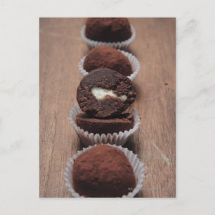 Row of chocolate truffles on wood postcard