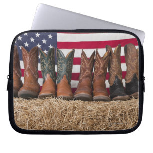 Row of cowboy boots on haystack laptop sleeve