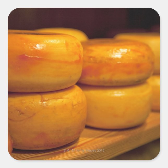 rows of colourful yellow Edam cheeses lined up Square Sticker (Front)