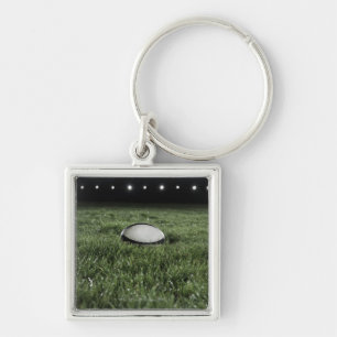 Rugby ball sitting on the grass pitch of a key ring