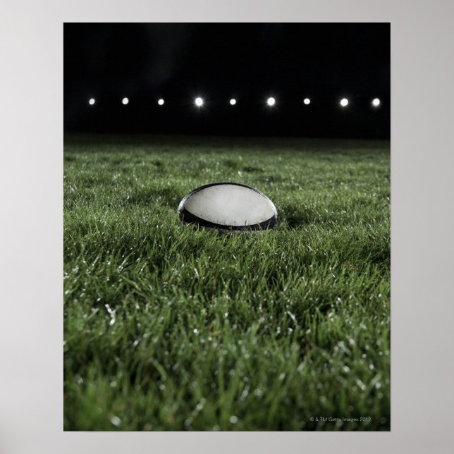 Rugby ball sitting on the grass pitch of a poster (Front)