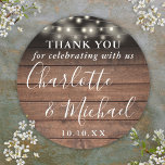 Rustic Wood String Lights Wedding Favour Thank You Classic Round Sticker<br><div class="desc">Rustic signature script wedding favour thank you classic round sticker featuring pretty string lights and signature style names on a wood panels background. Personalise with your special thank you information in chic white typography. Designed by Thisisnotme©</div>