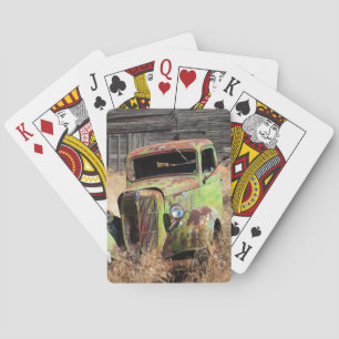 Rusting car in front of abandoned farm playing cards