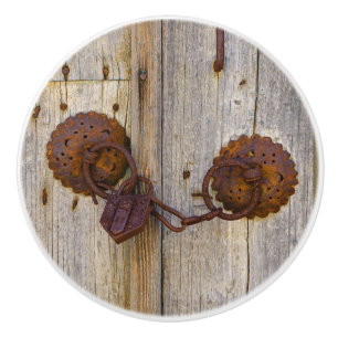 Rusty vintage old iron padlock on a wooden door :- ceramic knob