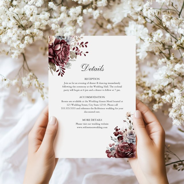 Sage Green & Burgundy Floral Wedding Details Card (Sage Green & Burgundy Floral Wedding Details Card in hands next to tiny white flowers)