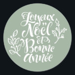 Sage Green Joyeux Noël and Bonne Année Christmas Classic Round Sticker<br><div class="desc">Add a festive French touch to your holiday gifts and cards with this sticker featuring “Joyeux Noël et Bonne Année” in modern calligraphy accented by holly illustrations. Perfect for decorating presents,  planners,  and holiday crafts,  this sticker brings elegance and seasonal cheer to any project.</div>