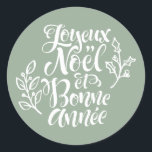 Sage Green Joyeux Noël and Bonne Année Christmas Classic Round Sticker<br><div class="desc">Add a festive French touch to your holiday gifts and cards with this sticker featuring “Joyeux Noël et Bonne Année” in modern calligraphy accented by holly illustrations. Perfect for decorating presents,  planners,  and holiday crafts,  this sticker brings elegance and seasonal cheer to any project.</div>