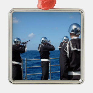 Sailors fire a gun salute during a burial-at-se metal tree decoration