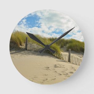 Sand dunes with wooden fence round clock