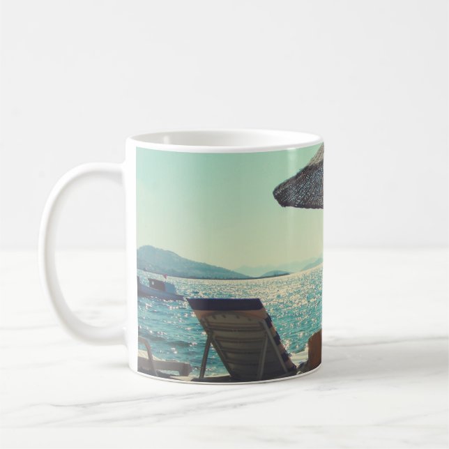 Sandy beach on a sunny afternoon,  with parasols a coffee mug (Left)