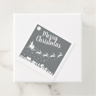 Santa's sleigh silhouette flying above the houses favour tags