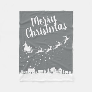 Santa's sleigh silhouette flying above the houses fleece blanket