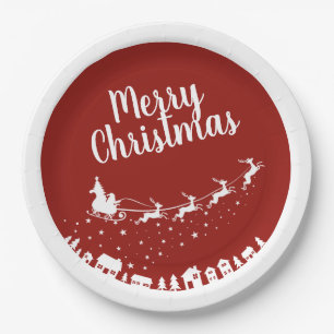 Santa's sleigh silhouette flying above the houses paper plate