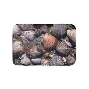 Scalloped Colourful Seashells On A Black Sand Bath Mat