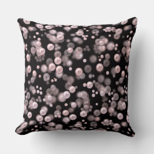Scatterings of pink and white pearls on black velv cushion