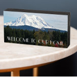 Scenic Mount Rainer Landscape Welcome Wooden Box Sign<br><div class="desc">A house welcoming,  wooden box sign designed for hanging or standing that features a scenic landscape photo image of snow covered Mount Rainier and a green valley in the Pacific Northwest state of Washington. Bold,  white letters read,  "WELCOME TO OUR HOME." Select from flat black or white painted wood.</div>