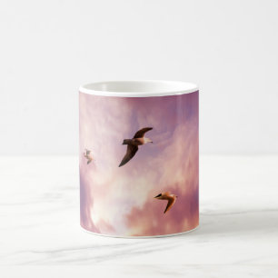 Seagulls flying in a sunset sky coffee mug