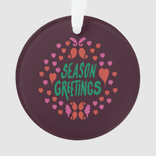 Season greetings in green handwriting with hearts ornament