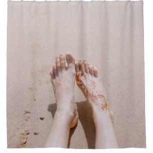 Selective focus photography of feet with tattoo on shower curtain