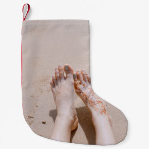 Selective focus photography of feet with tattoo on small christmas stocking