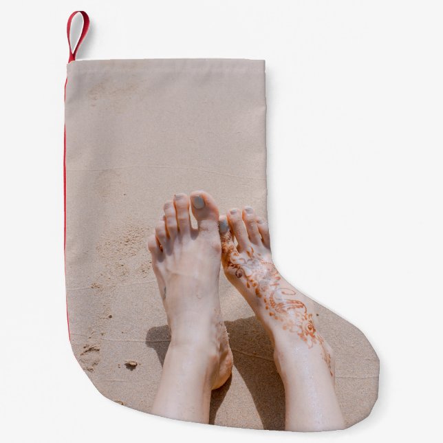 Selective focus photography of feet with tattoo on small christmas stocking (Front)