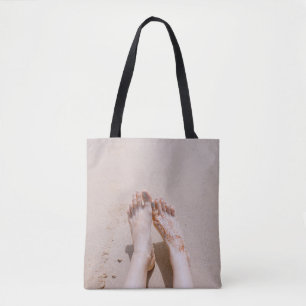 Selective focus photography of feet with tattoo on tote bag