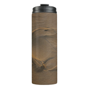 Selective focus photography of sand thermal tumbler
