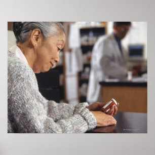 Senior woman in pharmacy reading medicine bottle poster