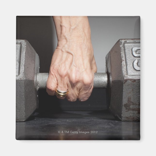 Senior woman lifting weights magnet (Front)