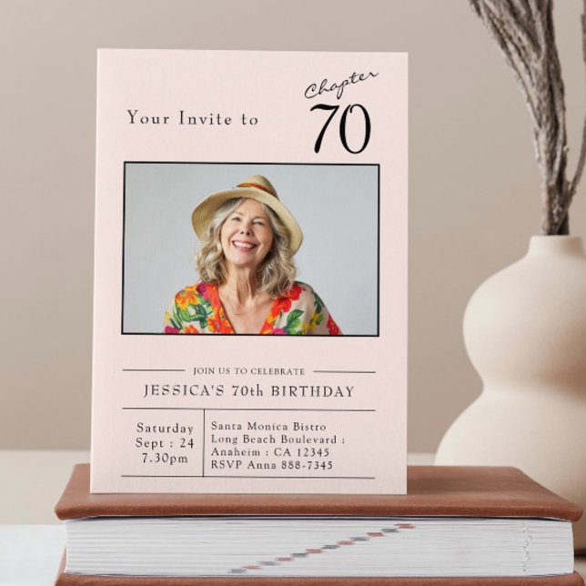 Seventy Blush Pink 70th Birthday Party Photo Invitation (Custom 70th birthday blush pink party invitation stood up on a book)