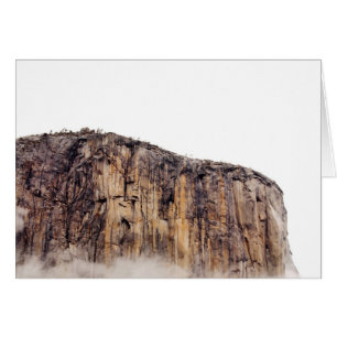 Sheer cliff rising above clouds