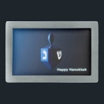 Shiny Blue Dreidel Belt Buckle<br><div class="desc">A modernistic,  metallic blue dreidel against a dark,  night-like background.  Two of the Hebrew letters found on a dreidel,  nun and shin,  glow brightly.  Text reading "Happy Hanukkah" also appears in glowing blue and white.</div>