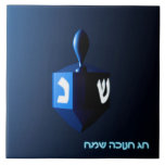 Shiny Blue Dreidel Tile<br><div class="desc">A modernistic, metallic blue dreidel against a dark, night-like background. Two of the Hebrew letters found on a dreidel, nun and shin, glow brightly. Hebrew text reading "Chag Chanukkah Sameach" (Happy Hanukkah) also appears in glowing blue and white.</div>