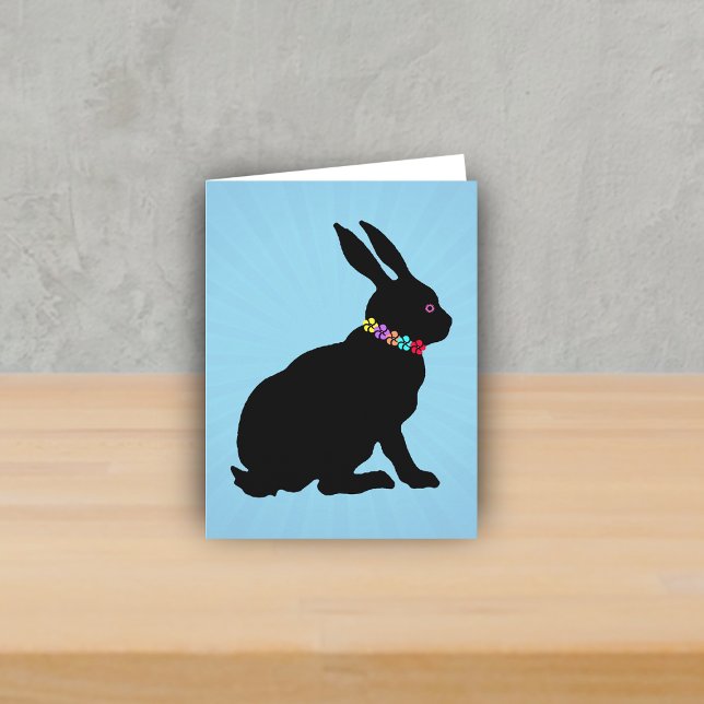 Side Profile sitting Black Rabbit Flowers Pink Eye Card (Black silhouette sitting rabbit wearing colourful flowers on Spring or Easter blue note card.)