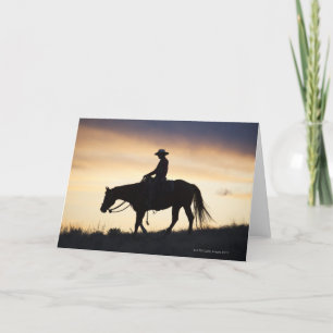 Silhouette of a Cowgirl on her horse against the Card