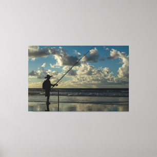 Silhouette of a Lone Fisherman on the Beach at Sun Canvas Print