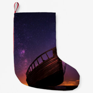 SILHOUETTE PHOTOGRAPHY OF SAILING BOAT ON BODY OF  SMALL CHRISTMAS STOCKING