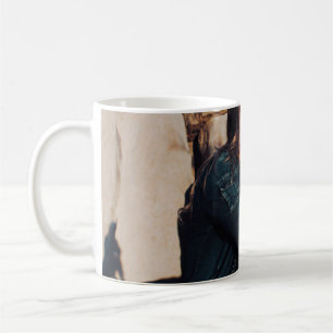 Sitting and smiling woman wearing black pants coffee mug