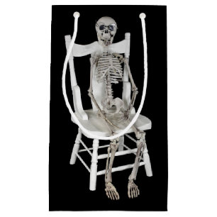 skeleton sitting on white chair small gift bag