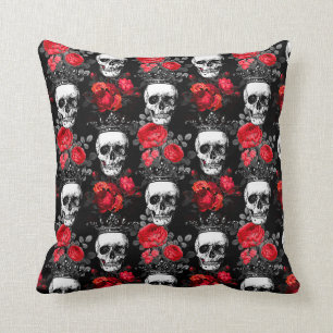 Skulls crowns and faded red roses on a dark black cushion